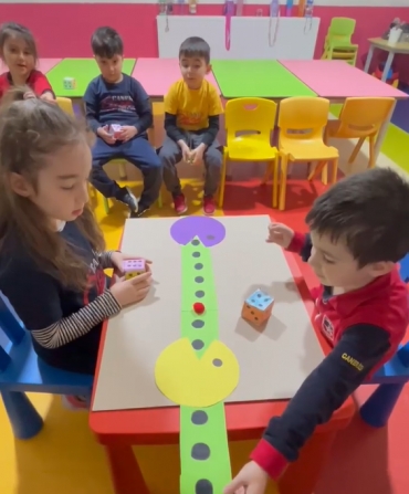 6 yaş C sınıfı Matematik dersinde küp şekilini öğreniyor ve pekmen oyunu ile eğlenceli dakikalar geçiriyor.