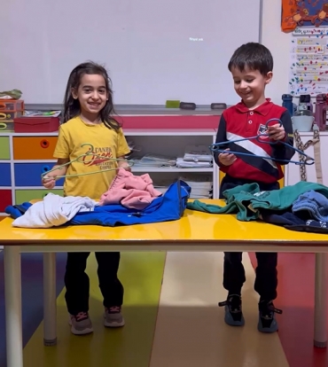 6 yaş B sınıfı Yaşam Becerileri dersinde kıyafetlerini askıya asmayı öğrendi.
