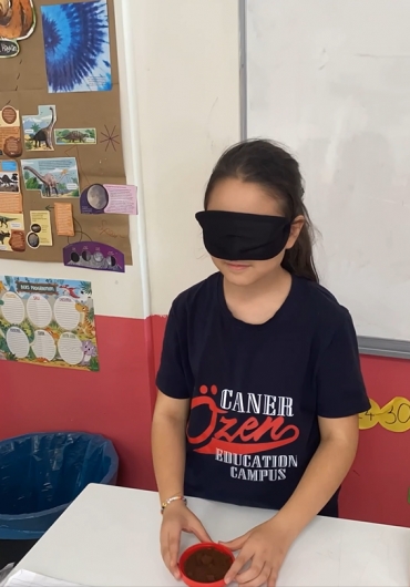 3/B sınıfı öğrencileri “Duyu Organları” konusunda görme duyusunu engelleyerek koku, tatma, ve dokunma duyularını kullanarak yiyecekleri ve nesneleri tahmin etti.